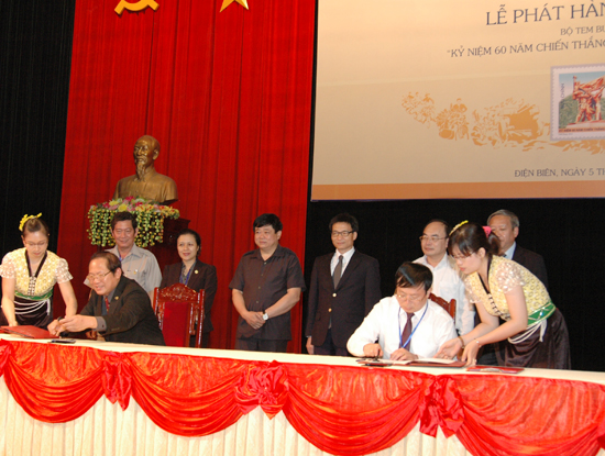 Thứ trưởng Bộ TT&TT Trương Minh Tuấn (ngồi bên trái) và Phó Chủ tịch UBND tỉnh Điện Biên Phạm Xuân Kôi  thực hiện nghi thức ký, đóng dấu phát hành đặc biệt bộ tem.